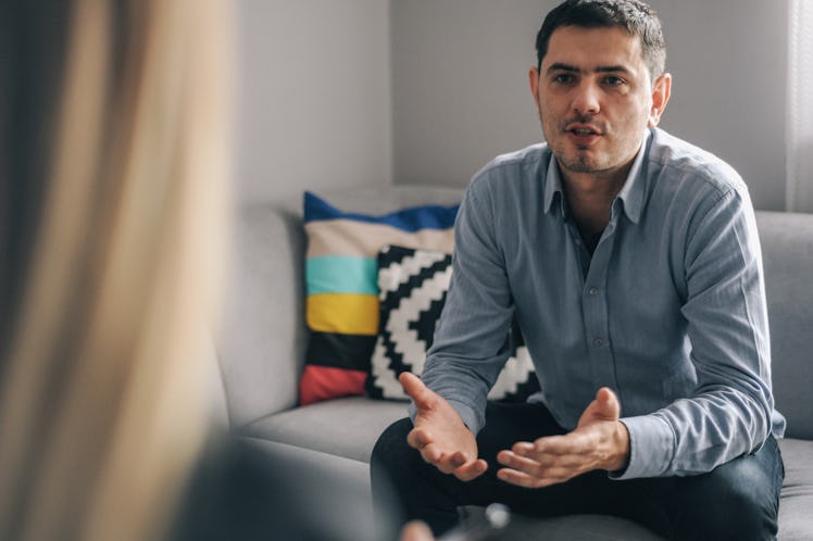 Man sitting on couch talking to friend