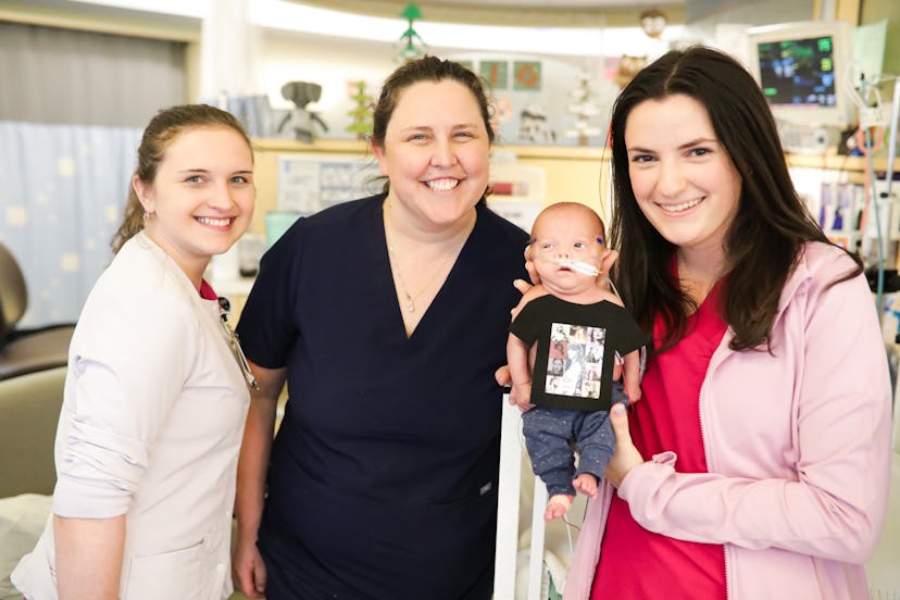 NICU nurses hold an infant dressed in a Taylor Swift t-shirt.