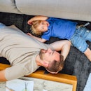 A child and dad lying on the floor, talking.