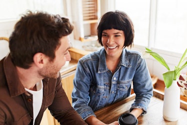 Man and woman smiling and talking at a counter