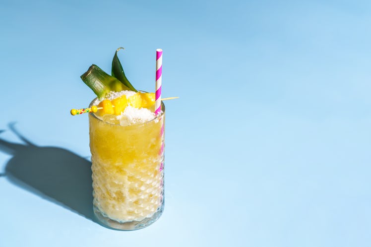 Pina Colada on blue background with straw 