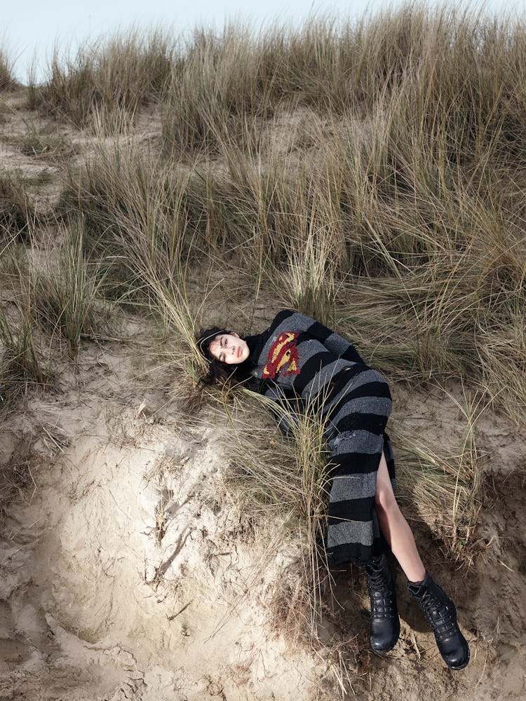 Model wears a superman gray and black striped dress and combat boots.