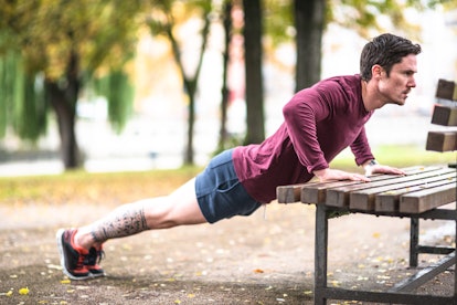 A man doing an incline push-up on a bench.