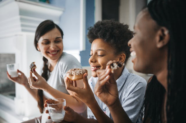 Moms eat donuts with their son.