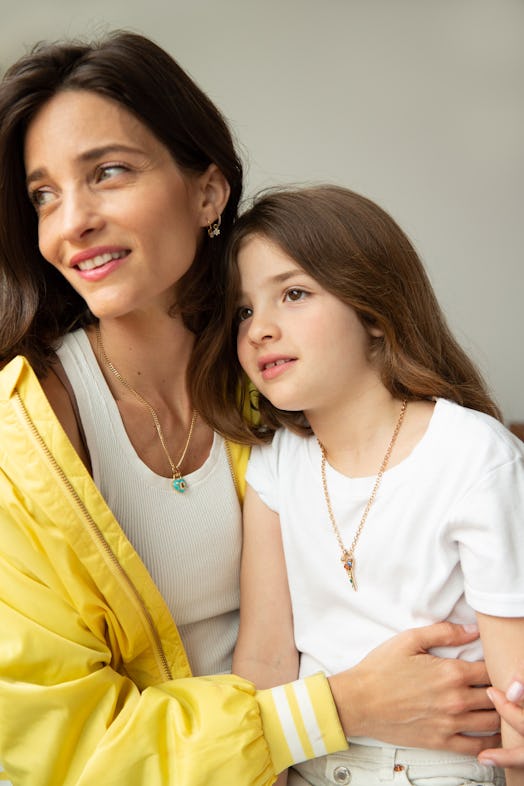 a mother and child in white t shirts looking to the left