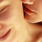A man kissing a woman's neck.
