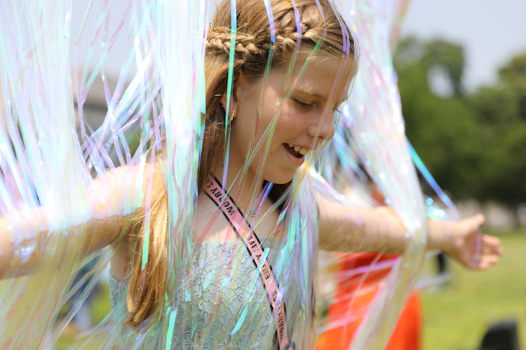 A child runs through shimmering streamers at Trans Prom.
