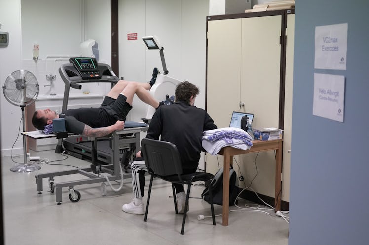 A person lies down and cycles vertically with foot pedals