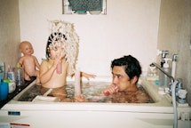 a man in the bath with his child playing