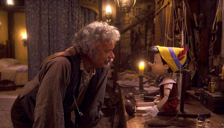 Tom Hanks' Gepetto looks at a wooden puppet in 2022's Pinocchio 
