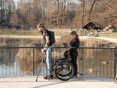 Oksam and a scientist walk across a bridge.