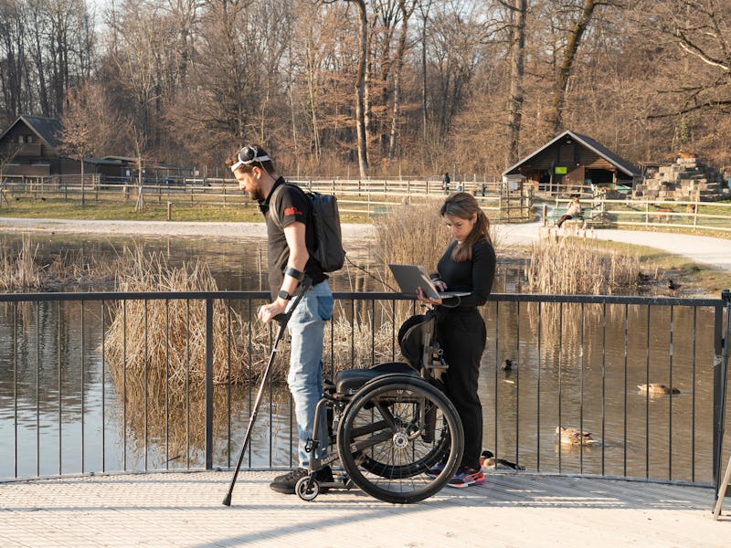 Oksam and a scientist walk across a bridge.
