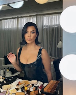 Kourtney Kardashian black nails sitting at makeup table