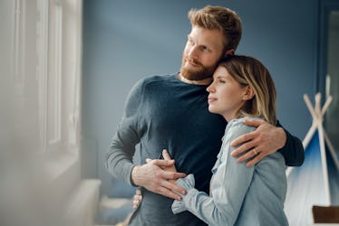 Portrait of husband and wife with husband's arm around wife