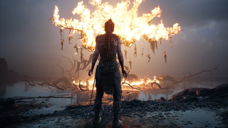 Hellblade Senua in front of a burning tree
