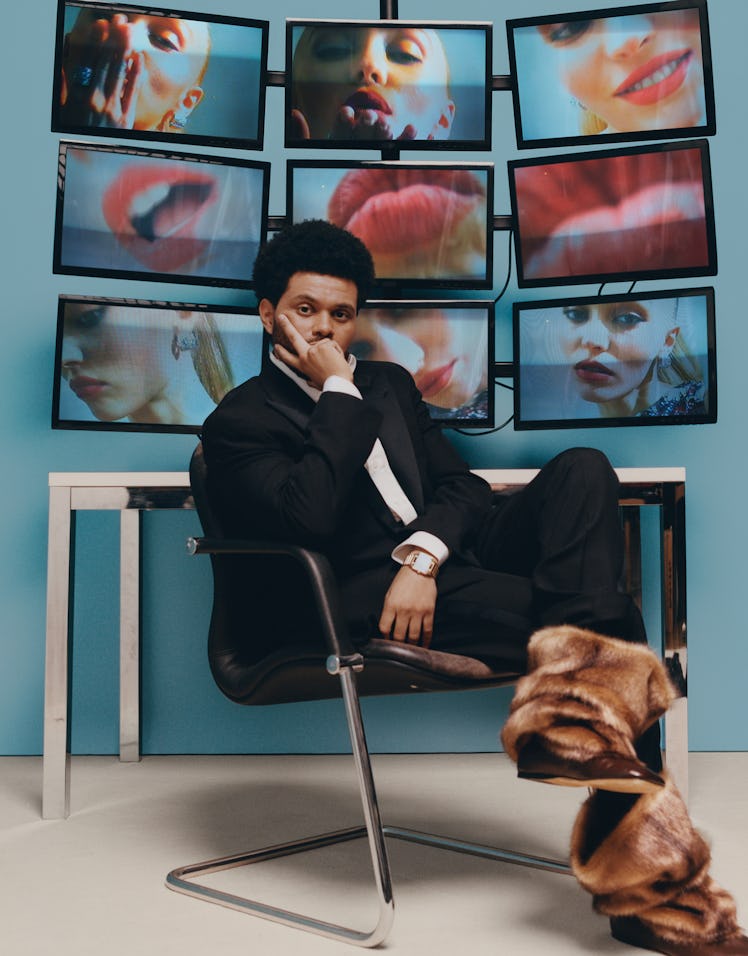 The Weeknd wears a gold watch, black tuxedo, fur boots and white button-down shirt.