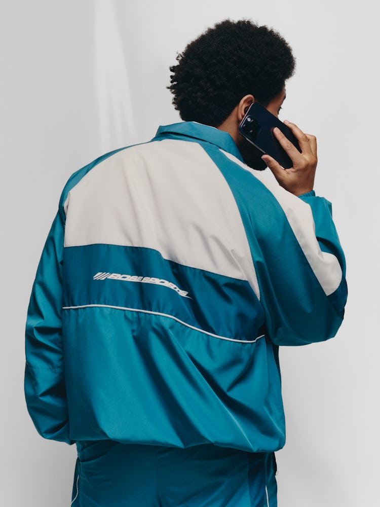 The Weeknd wears a green & white windbreaker suit.