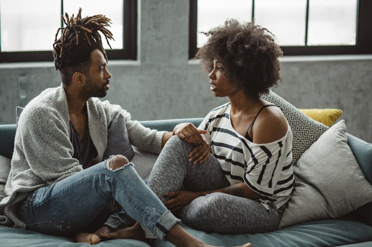 Couple sitting on couch having intimate discussion