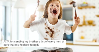 Messy little boy with stains having fun while eating chocolate spread in the kitchen.