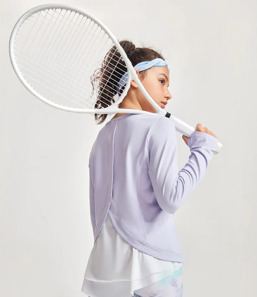 model rocking moody tiger cute activewear clothes for kids, holding a tennis racket