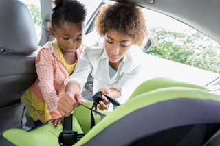 A mom and her child clean a car seat.