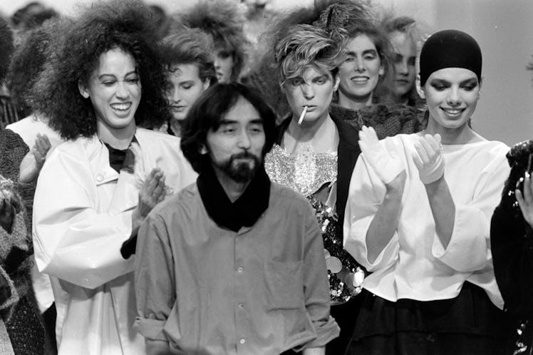 Designer Yohji Yamamoto takes a bow on the runway with model Pat Cleveland