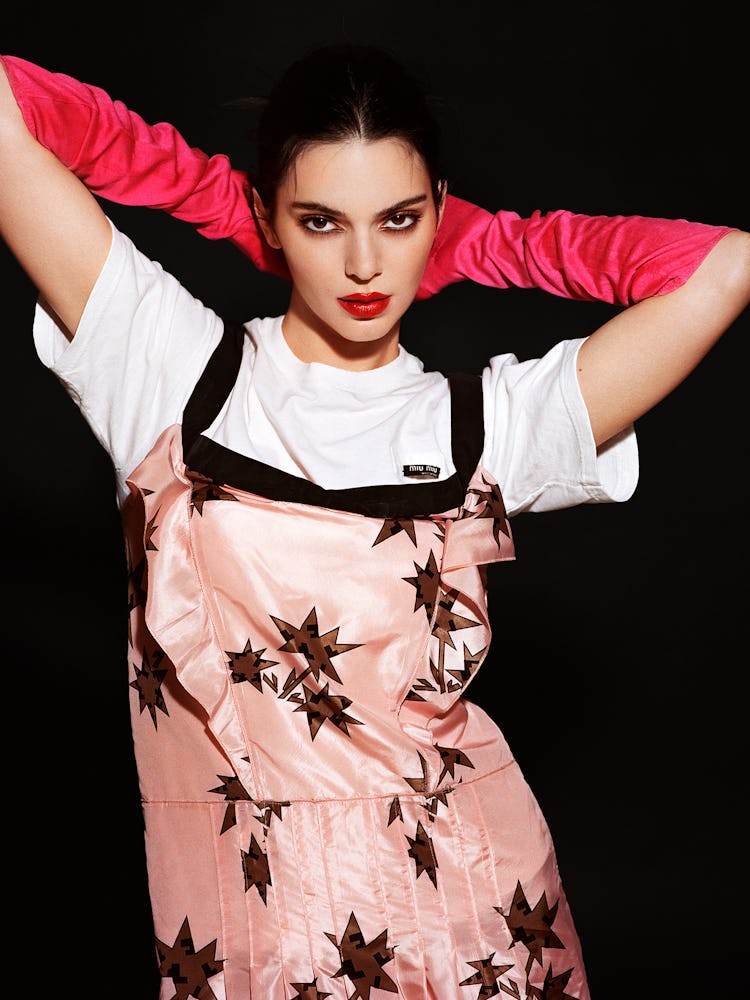 Kendall Jenner wears a long red gloves, white t-shirt and pink printed dress.