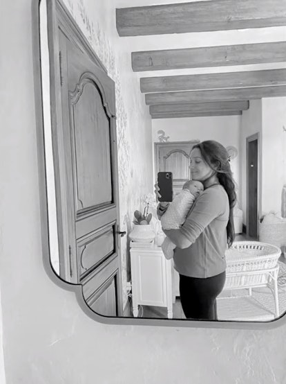 A mirror selfie of Meghan Markle holding baby Lilibet