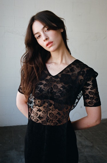 Gracie Abrams wears a floral laced dress and leggings.