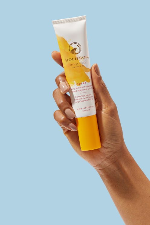 HoliFrog Solar Daily Mineral Sunscreen in hand against blue background