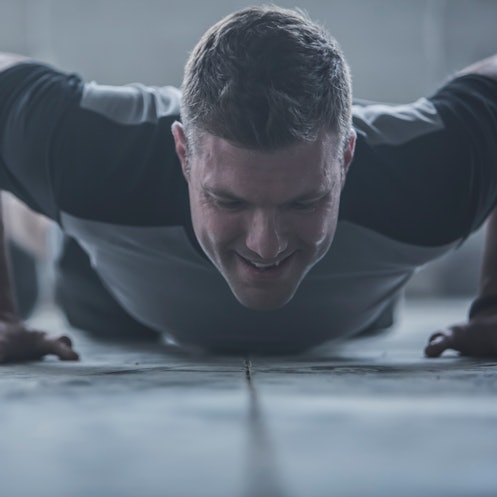 A man doing push-ups to lose belly fat.