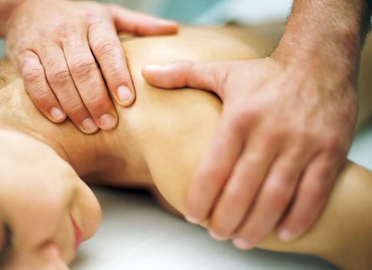 Close-up image of a man massaging a woman's neck and shoulders
