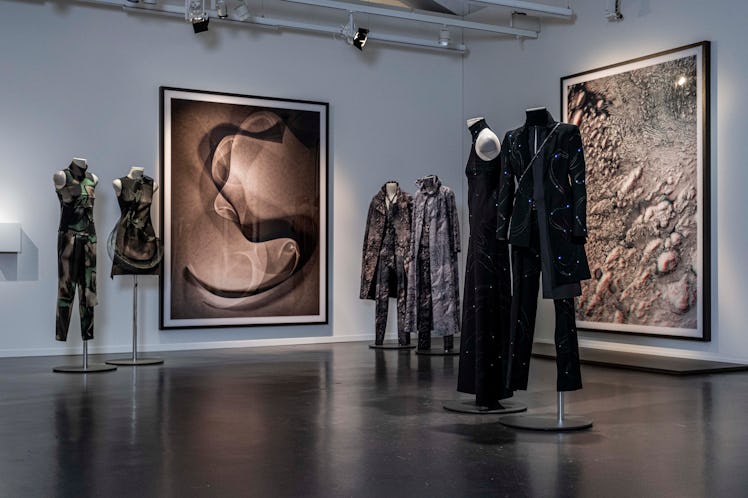 mannequins wearing LED light-embroidered clothing in a gallery with photographs by Thomas Ruff