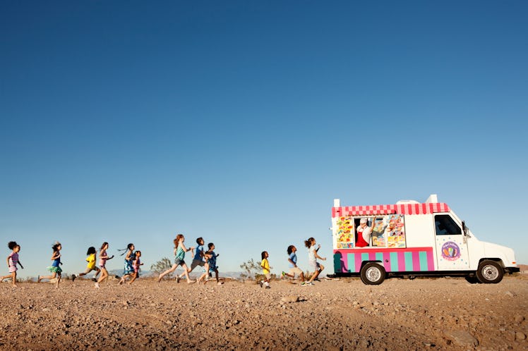 Young children running towards the ice cream truck