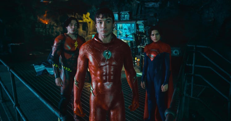 Two versions of Barry Allen (Ezra Miller) stand in the Batcave with Supergirl (Sasha Calle) in The F...