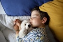 一个婴儿和毛绒玩具一起睡在床上。
