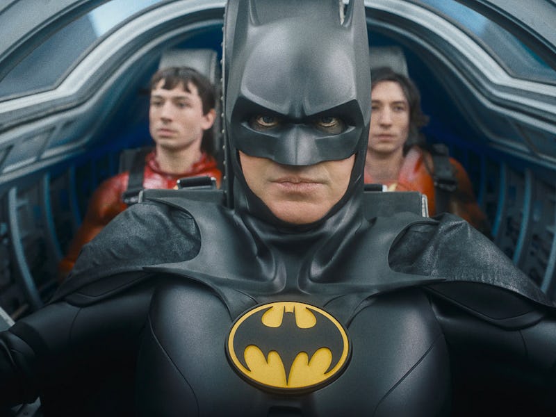 Two versions of Barry Allen (Ezra Miller) sit behind Batman (Michael Keaton) in The Flash