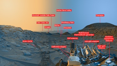 color image of a valley on Mars, with yellow sky on the left and blue sky on the right, and a rover ...