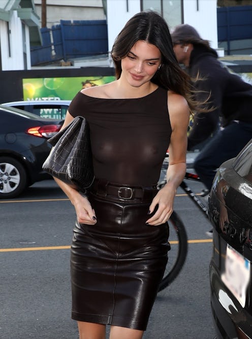 Kendall Jenner wears a see-through top, leather skirt, boots, and a clutch while out in California.