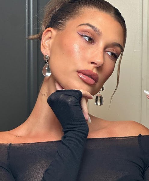 Hailey Bieber bun with white chrome nails