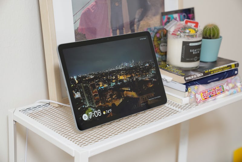Google Pixel Tablet in Hub Mode sitting on a shelf showing digital pictures from Google Photos