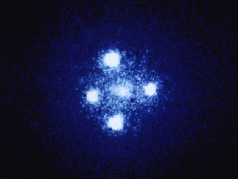 A gravitational lens caused by a galaxy in the foreground leading to an "Einstein Cross.