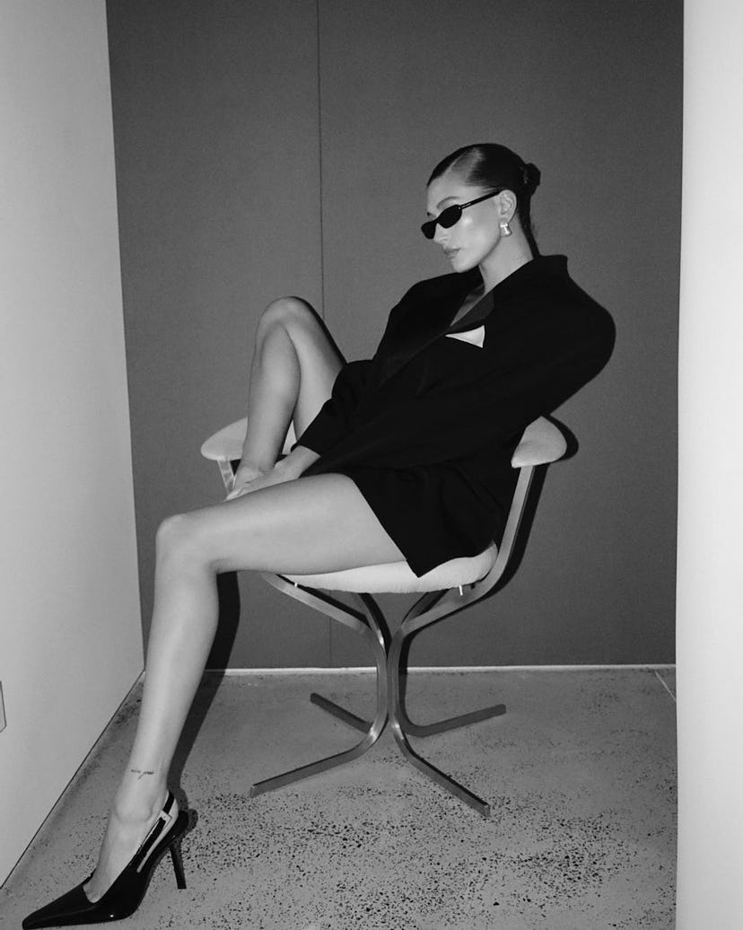 Hailey Bieber sitting in a chair wearing YSL