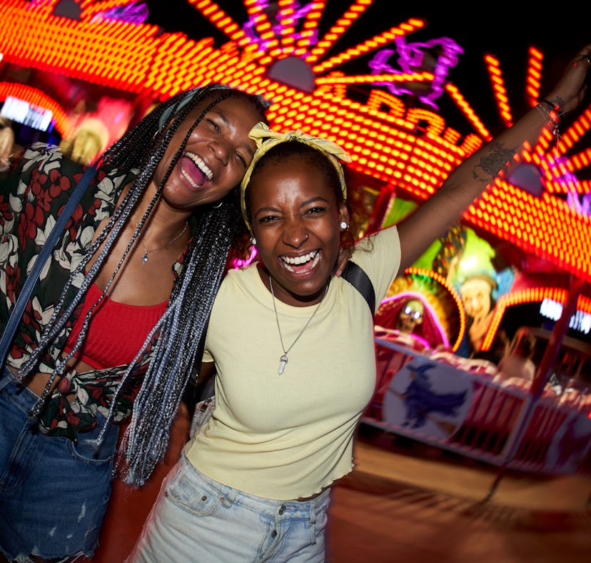 Two friends laughing at an amusement park during Neptune retrograde 2023.