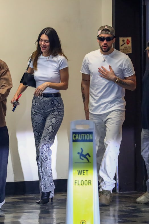 Kendall Jenner wears a white t-shirt and blue snakeskin pants while in Los Angeles with Bad Bunny.