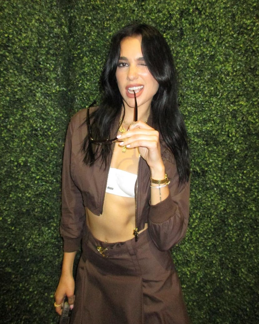 Dua in a brown co-ord outfit balancing a bag on her head