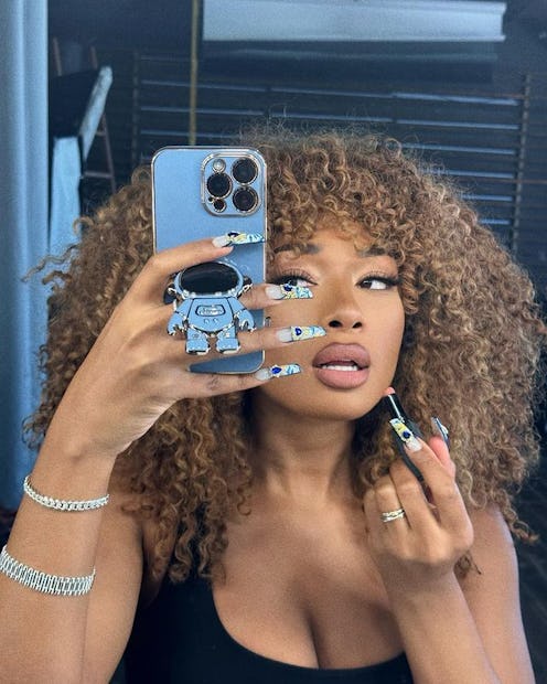 Megan Thee Stallion curly blonde hair and purple phone case