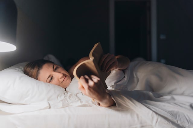 A woman reads in bed