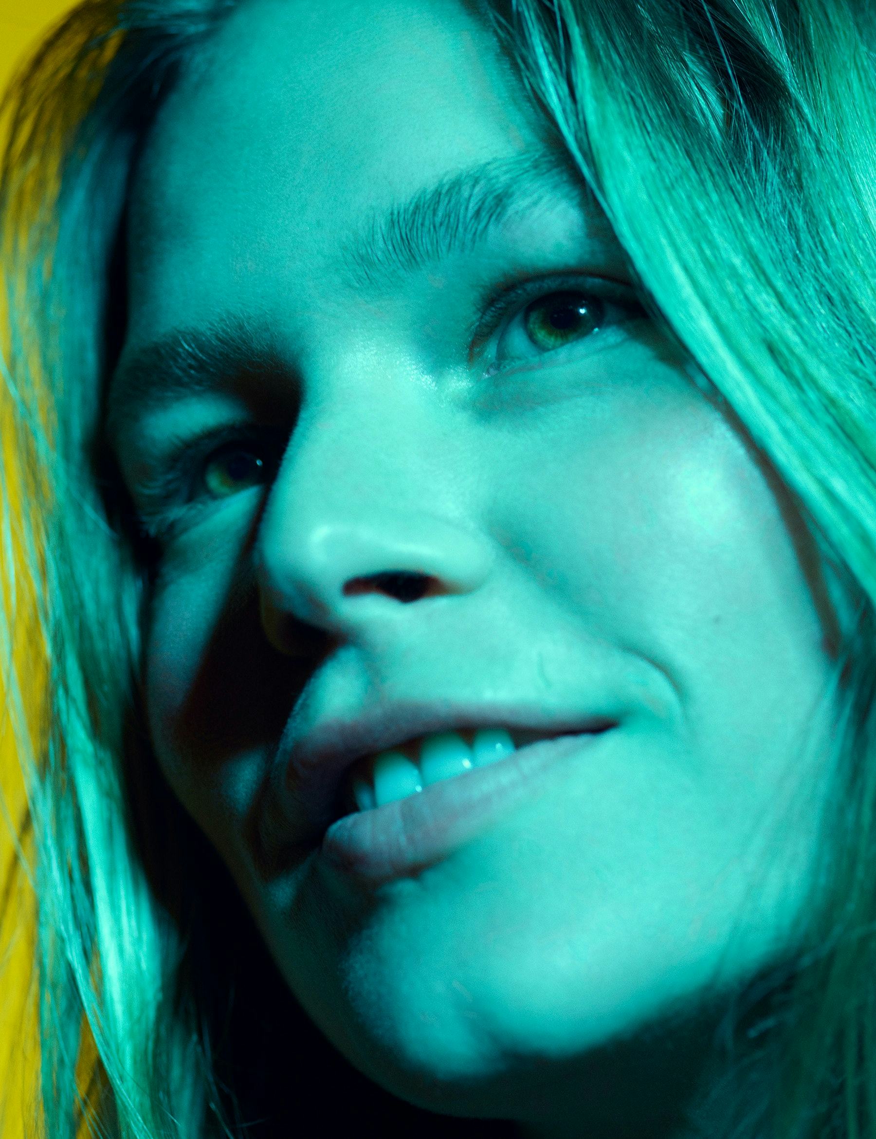 A close-up of the model Anna Ewers bathed in blue light. 