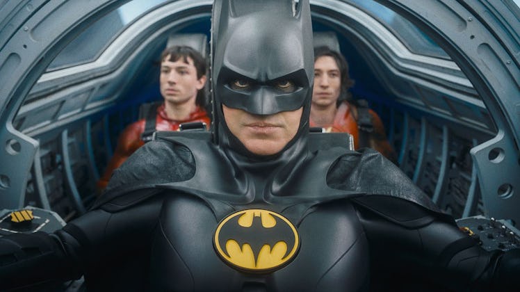Two versions of Barry Allen (Ezra Miller) sit behind Batman (Michael Keaton) in the Batwing in 2023'...